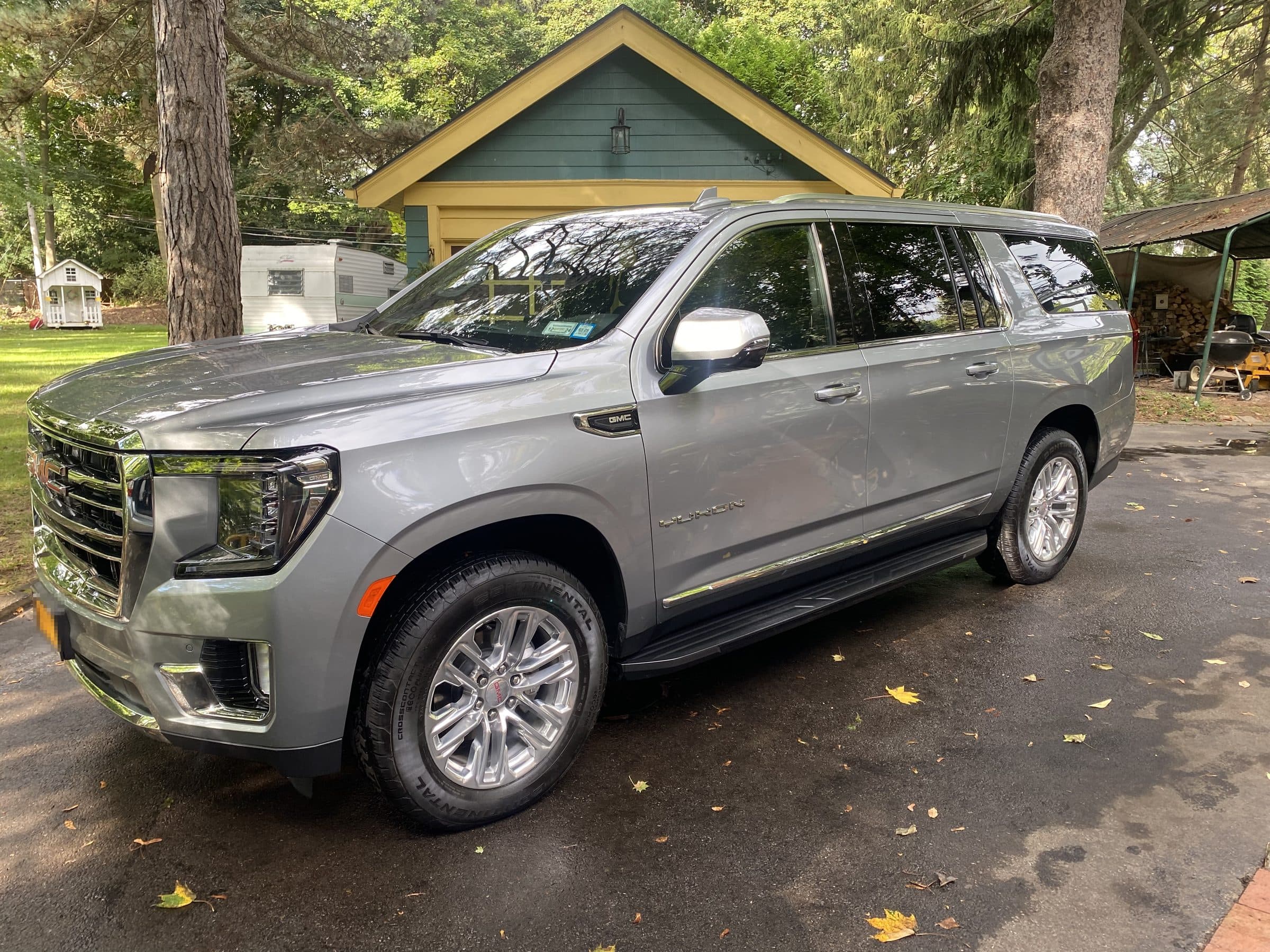 A freshly detailed silver SUV standing in a residential driveway, paint and trim clean